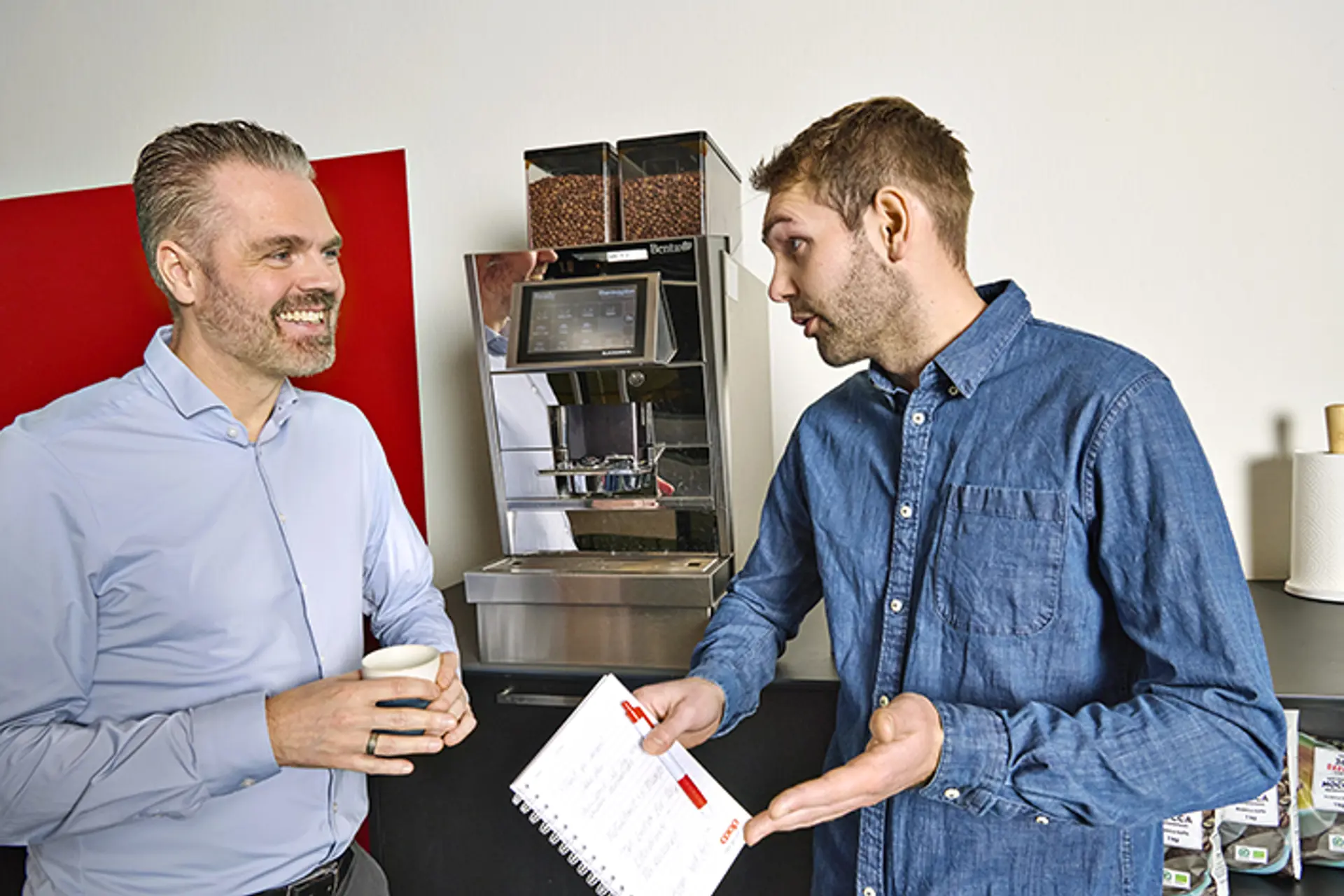 Medarbejdere i snak foran kaffemaskine